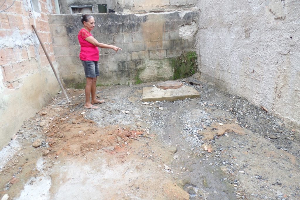Dona Maria José mostra o local onde começa a passagem das manilhas no quintal dela. foto: João Thomazelli/Portal 27
